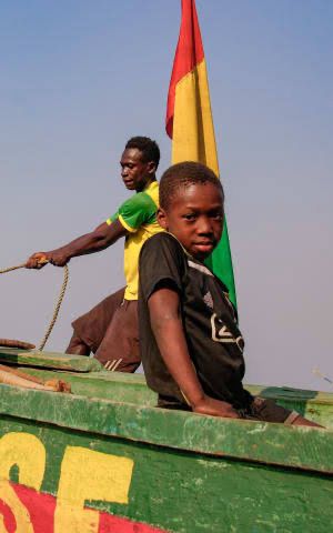Des jeunes dans un bateau pêchant en Guinée